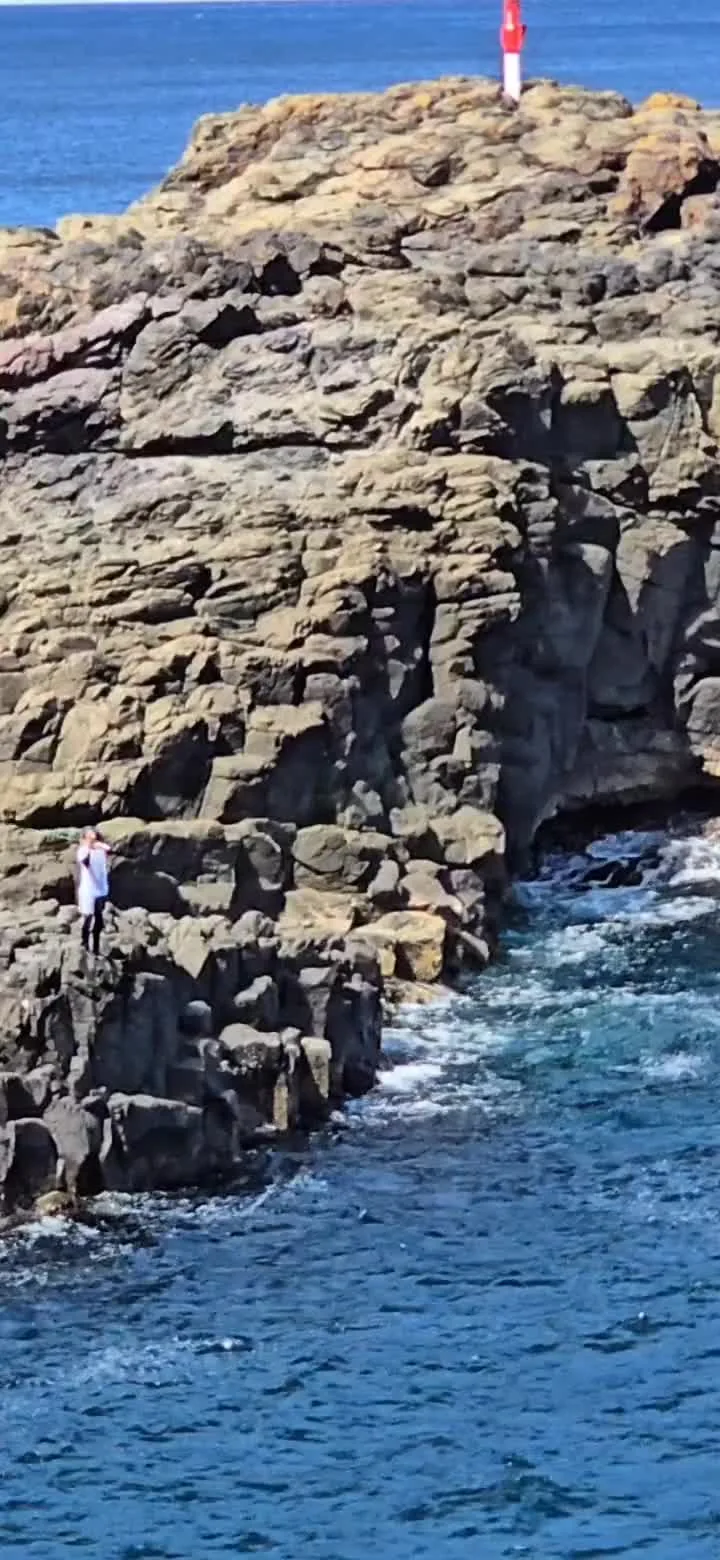 Original frame from Alex’s Kiama field-data post, showing people on a rock platform above the water.